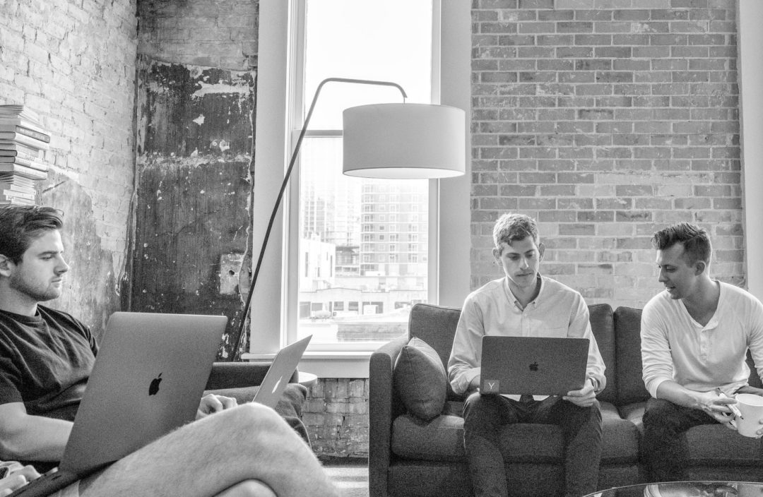 three men on computers working